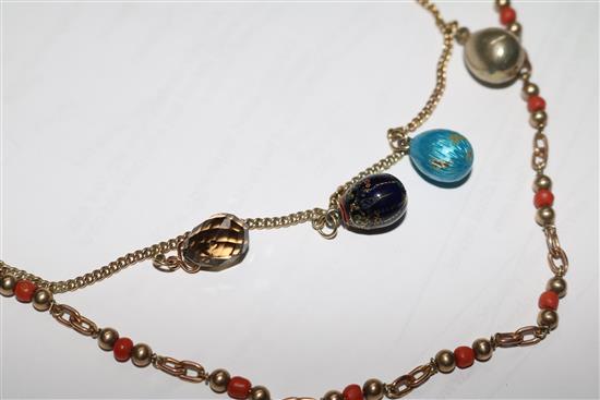 A 9ct gold necklace hung with four egg shaped charms and a 9ct gold and coral bead necklace.